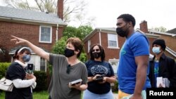 Voluntarios llevan a cabo una campaña de puerta en puerta para convencer a las personas a vacunarse contra el coronavirus en Detroit, Michigan, EE. UU., el 4 de mayo de 2021.