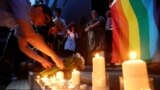 Singers Anthony Wong, left, and Denise Ho, who have announced their homosexual status, lay flowers during a candlelight vigil to mourn victims of the Pulse Orlando shooting, Hong Kong, China, June 13, 2016.