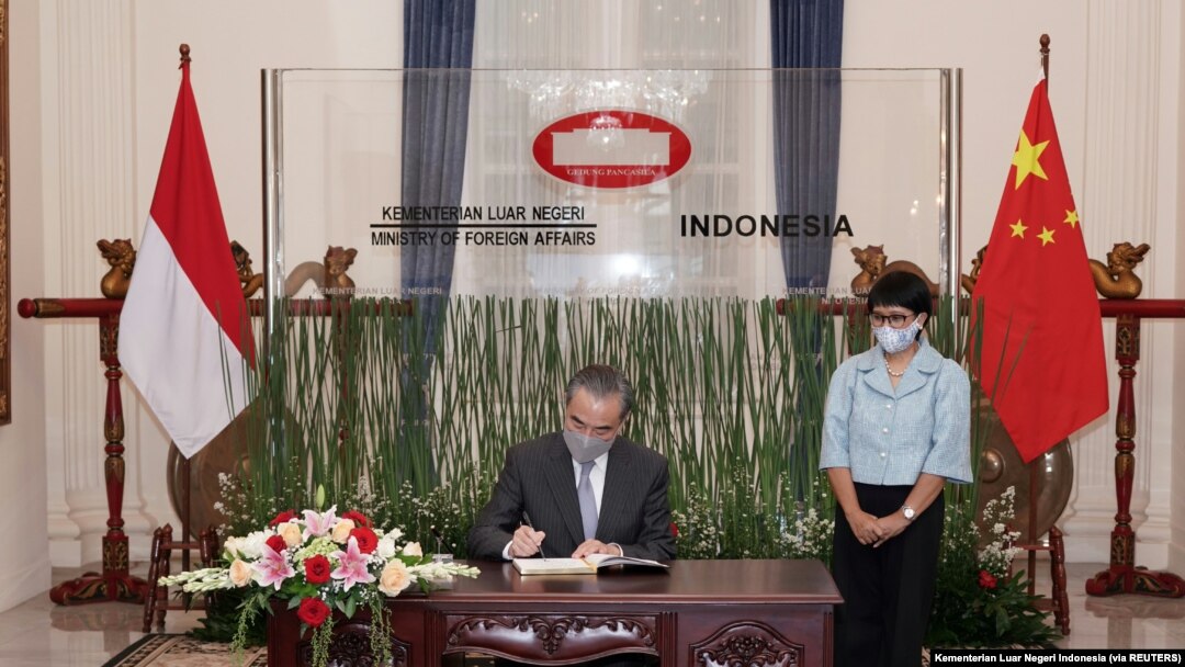 Menteri Luar Negeri Wang Yi menandatangani buku tamu saat Menteri Luar Negeri Retno Marsudi berdiri di sampingnya saat rapat di Jakarta, 13 Januari 2021. (Foto: Kementerian Luar Negeri Indonesia via REUTERS)
