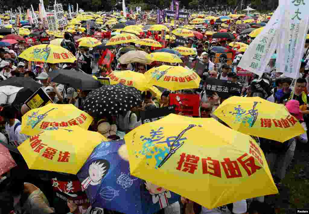 2019年6月9日在中國香港，示威群眾要求當局廢除擬議中的把犯人引渡到中國的法案。他們手持黃色雨傘，這是過去的佔領中環運動的象徵。