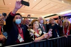 People listen as President Donald Trump speaks on stage as he visits the Republican National Committee convention site, Aug. 24, 2020, in Charlotte.