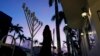 A woman walks past a menorah outside a Jewish synagogue ahead of the start of Hanukkah, in Miami Beach, Florida, on Dec. 1, 2023. A new guide from the Department of Homeland Security aims to help houses of worship protect themselves at a time of heightened tensions in the U.S.