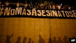 FILE - A banner reads in Spanish "No more murders" during a vigil in Caracas, Venezuela, June 8, 2017. The vigil was in honor of a victim of months-long street demonstrations in Caracas. The more than 100 people who died in the protests are not included in government count.