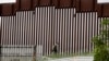 ARCHIVO - Un agente de la Patrulla Fronteriza de EEUU camina junto a una valla que separa a Tijuana, México, de San Diego, en San Diego, el 18 de marzo de 2020