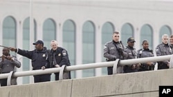 Law enforcement officers search along the I-395 expressway adjacent to the Pentagon for evidence of possible shots fired, 19 Oct 2010