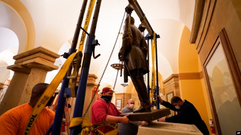 This Dec. 21, 2020 photo provided by the Office of the Governor of Virginia shows workers removing a statue of Confederate Gen. Robert E. Lee from the National Statuary Hall Collection in Washington.