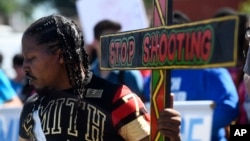 Joseph Saunders carries a cross at a protest July 7, 2018, in Chicago. The protesters were attempting to increase pressure on public officials to address the gun violence that's claimed hundreds of lives in some of the city's poorest neighborhoods. 