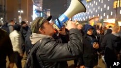 In this image taken from video, demonstrators protest against government restrictions implemented because of the coronavirus pandemic, Nov. 19, 2021, in Rotterdam, Netherlands.