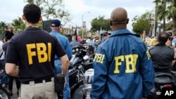 Les agents du FBI regardent le défilé de la fierté gay débute à West Hollywood, en Californie, le 12 Juin 2016.