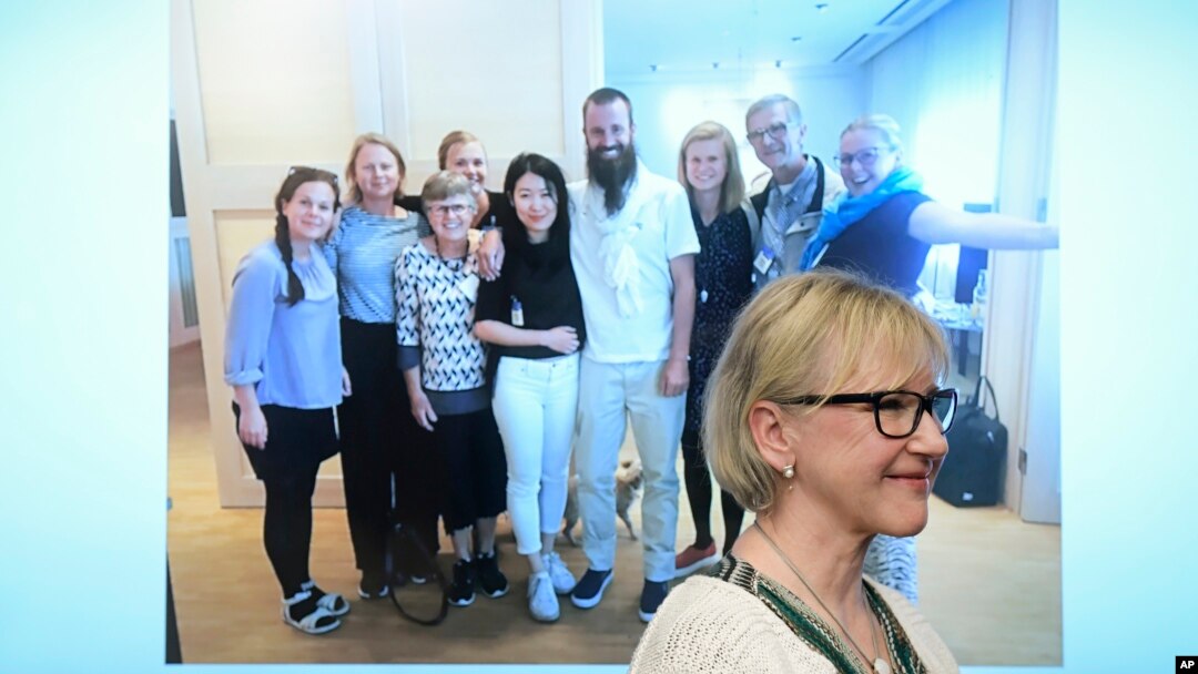 Menlu Swedia, Margot Wallstrom, tersenyum di depan foto pria Swedia yang baru saja dibebaskan di Mali, Johan Gustafsson (tengah) bersama keluarganya setelah bebas (26/6). 