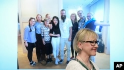 Menlu Swedia, Margot Wallstrom, tersenyum di depan foto pria Swedia yang baru saja dibebaskan di Mali, Johan Gustafsson (tengah) bersama keluarganya setelah bebas (26/6). 