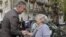FILE - Montenegrin leader Milo Djukanovic talks to a supporter in front of a polling station in downtown Podgorica, Oct. 14, 2012.