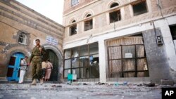 Houthi rebels inspect scene at al-Balili mosque after two suicide bombings during Eid al-Adha prayers in Sanaa, Yemen, Sept. 24, 2015.