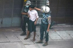 Riot police detain a demonstrator during a protest against the military coup in Yangon, Myanmar, March 19, 2021.