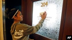Diana Hodges places a sticky note that calls for freeing 22-year old Daniela Vargas, a Argentine native who has lived in the United States since she was seven years old, on the office doors of lawmakers at the Capitol in Jackson, Miss., Friday, March 3, 2017, Vargas was detained, March 1, by immigration agents who state that she is a "unlawfully present Argentinian citizen" during a "targeted immigration enforcement action."