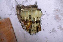 Israeli security forces inspect a damaged synagogue after it was hit by a rocket fired from the Gaza Strip, in Ashkelon, May 16, 2021.