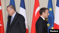 FILE - French President Emmanuel Macron (R) and his Turkish counterpart, Recep Tayyip Erdogan, walk past each other during a joint press conference at the Elysee Palace in Paris, France, Jan. 05, 2018.