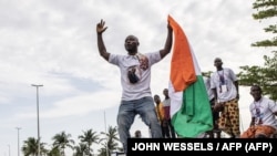 Supporters of Laurent Gbagbo react as his plane lands in Abidjan on June 17, 2021. -