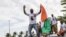 Supporters of Laurent Gbagbo react as his plane lands in Abidjan on June 17, 2021. -