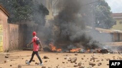 Protesters burn barricades and tires on a street during a demonstration in Conakry, Guinea, Oct. 14, 2019..