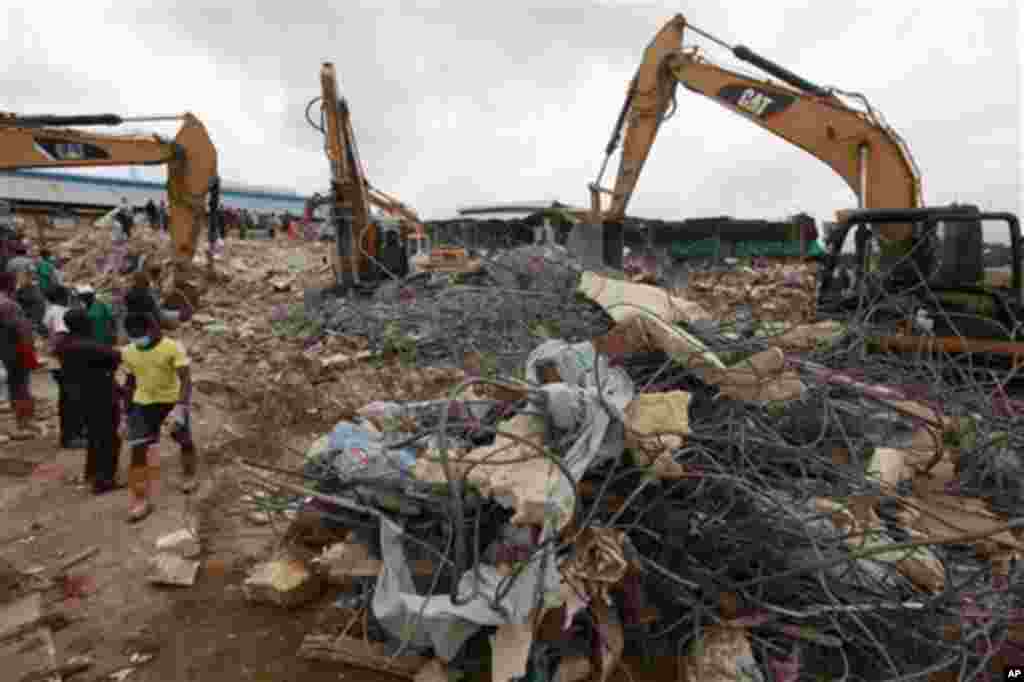 Ma'aikatan agaji suna neman masu rai a ginin Cocin daya rushe mallakan Cocin Synagogue, a Lagos, 16 ga Satumba, 2014.