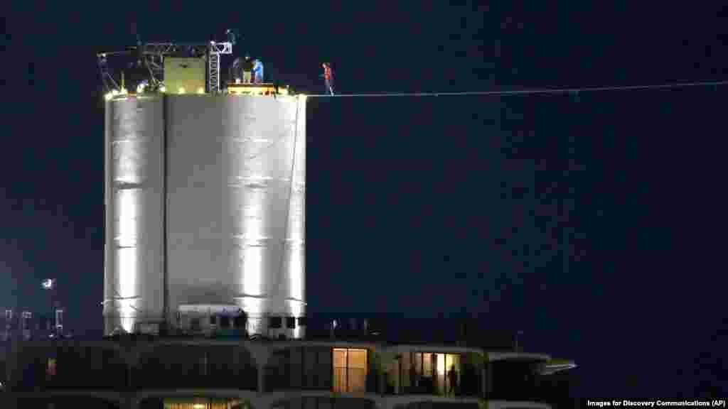 Tay mạo hiểm Nik Wallenda bước ra trên dây và đi ngược trở lại để quay phim trước khi thực hiện cuộc đi bộ giữa hai tòa nhà chọc trời ở Chicago, ngày 2/11/2014.&nbsp; 