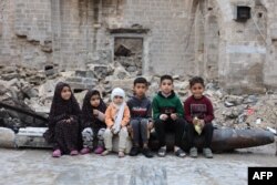 FILE—Children pose on April 10, 2024 in the courtyard of Gaza City's historic Omari Mosque, which has been heavily damaged in Israeli bombardment during the battles between Israel and Hamas, after the morning prayer on the first day of Eid al-Fitr.