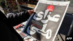 An Iranian man checks a local newspaper headline that reads "National Mourning" refering to the downed Ukranian jetliner outside the capital Tehran last week, in front of a news stand in the Islamic republic's capital Tehran on January 12, 2020. -…