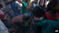 Niños refugiados de Tigray, Etiopía, se disputan mascarillas y gel desinfectante donados por la oenegé Maarif, en el campo de refugiados Umm Rakouba de Mercy Corps, en Qadarif, Sudán Oriental. Dic. 10 de 2020.