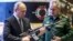 El presidente ruso, Vladimir Putin (izq), y el ministro de Defensa ruso, Sergei Shoigu, visitan una exhibición militar después de asistir a una reunión de la Junta del Ministerio de Defensa de Rusia en el Centro de Control de Defensa Nacional en Moscú, el 21 de diciembre de 2021.