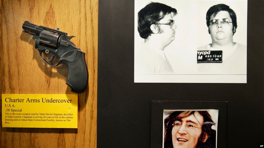 FILE - The gun used by Mark David Chapman to kill John Lennon is displayed next to their pictures at a small museum in the Forensic Investigation Division of the New York Police Department in New York, Dec. 8, 2015. 