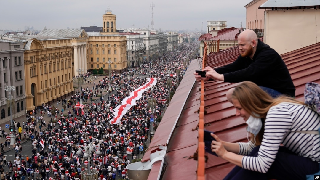 Pristalice beloruske opozicije sa krovova gledaju marš hiljada građana ka Trgu nezavisnosti u Minsku, 23. avgusta 2020. 