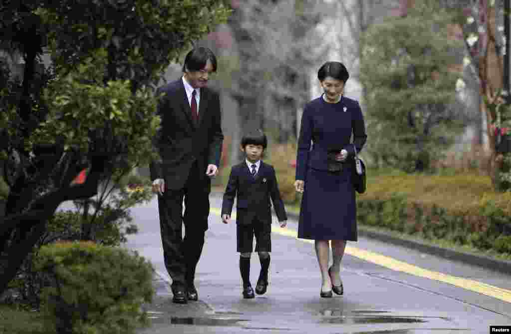 Pangeran Jepang Hisahito (tengah), didampingi ayahnya Pangeran Akishino (kiri) dan ibunya Putri Kiko, tiba di Taman Kanak-kanak yang berafiliasi dengan Universitas Ochanomizu untuk upacara wisudanya di Tokyo.