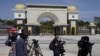 FILE - Journalists are seen gathered outside the National Palace, in Kuala Lumpur, Malaysia, Feb. 27, 2020.