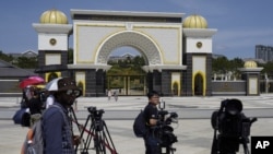 FILE - Journalists are seen gathered outside the National Palace, in Kuala Lumpur, Malaysia, Feb. 27, 2020.