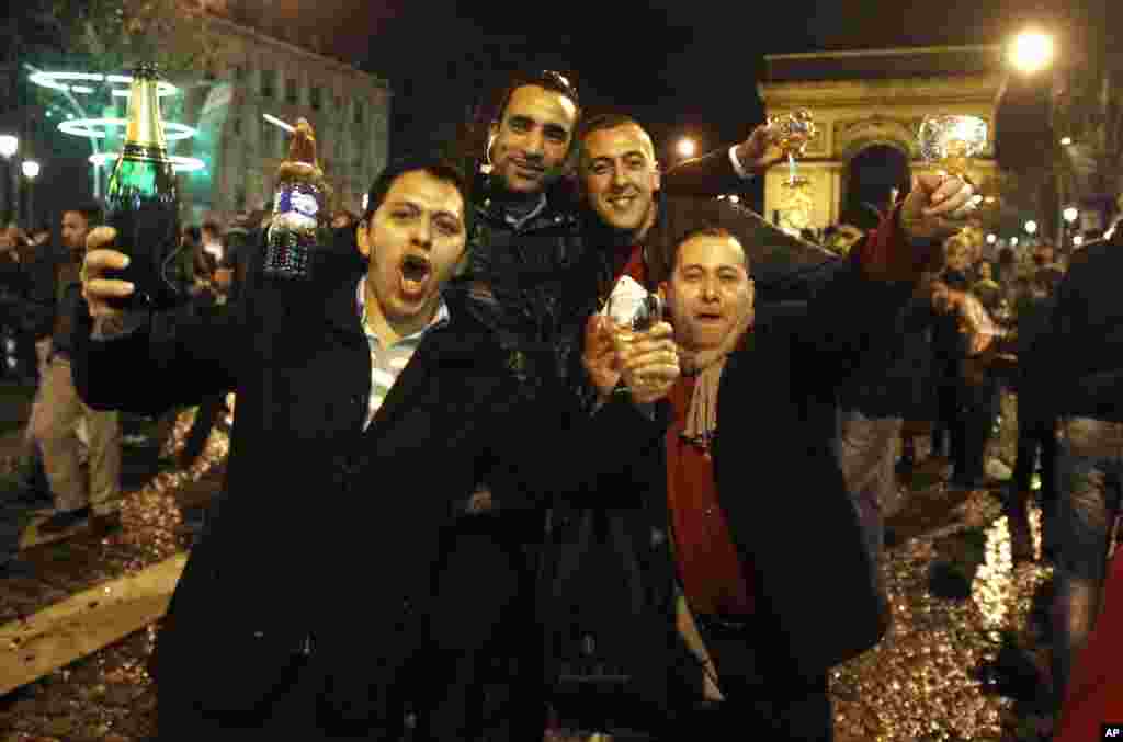 Revelers celebrate the New Year on the Champs Elysees in Paris, Sunday Jan. 1, 2012. Visible in background is the Arc de Triomphe.(AP)