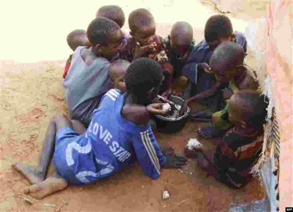 Somali refugee children from southern Somalia eat food in front of their makeshift shelter at a camp for displace people in Mogadishu, Somalia, Saturday , Aug, 6, 2011, The United Nations says famine will probably spread to all of southern Somalia within