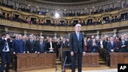 El nuevo presidente de Austria, Alexander Van der Bellen, rodeado de legisladores en el Parlamento en Viena, luego de ser juramentado.