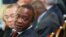 FILE - Kenya's President Uhuru Kenyatta turns to speak to a member of his delegation at the Somalia conference in London on May 7, 2013. 