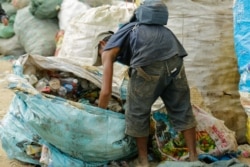 A man rummages through trash at Dangkor Landfill, in Phnom Penh, Cambodia, Dec. 31, 2019. (Tum Malis/VOA Khmer)