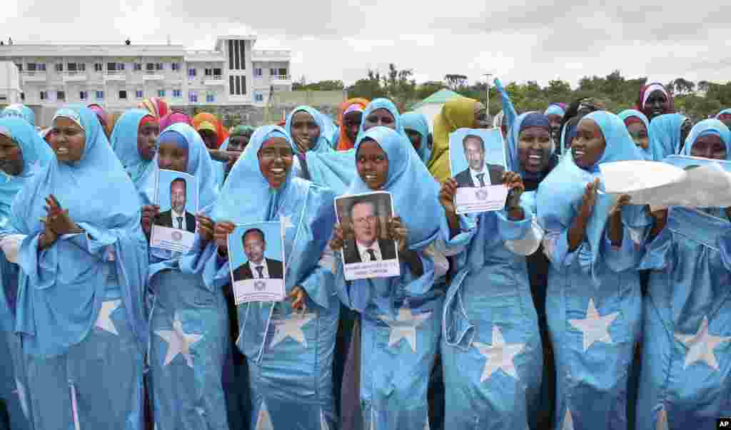 Demonstrators supporting the Somalia conference in London hold placards and photos of British Prime Minister David Cameron and Somali President Hassan Sheikh Mohamud in Mogadishu, Somalia, May 7, 2013.