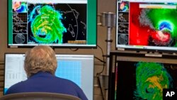 FILE - A hurricane specialist works at the National Hurricane Center in Miami, Sept. 10, 2017.