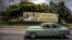 A man drives a vintage American car next to a display — which reads "Welcome to Cuba Pope Francis" in Spanish — at Revolution Square in Havana, Cuba, Sept. 15, 2015.