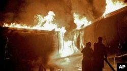 Pakistani fire fighters struggle to extinguish burning oil tankers after militants attacked a terminal in Rawalpindi, Pakistan, early Monday, 4 Oct. 2010.