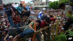 Thousands of Honduran migrants rush across the border toward Mexico, in Tecun Uman, Guatemala, Oct. 19, 2018. 