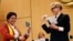 UNHCR goodwill ambassador and actress Cate Blanchett (R) and formerly stateless refugee Maha Mamo (L) show passports during the UNHCR's Executive Committee meeting in Geneva, Switzerland, Oct. 7, 2019.