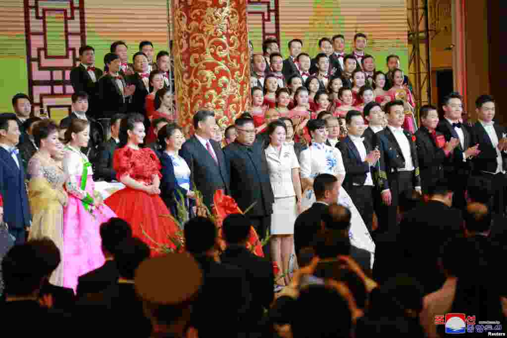 2018年6月19日，中国国家主席习近平和夫人，朝鲜领导人金正恩和夫人参加欢迎宴会，观赏文艺演出后和歌唱家殷秀梅等演员们合影。6月20日，金正恩访华两天后返回平壤。中国是贫困的朝鲜的主要经济和外交盟友。