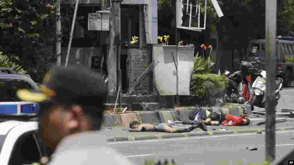 Bodies lie on the street next to a police post where an explosion went off in Jakarta, Indonesia Thursday, Jan. 14, 2016. 