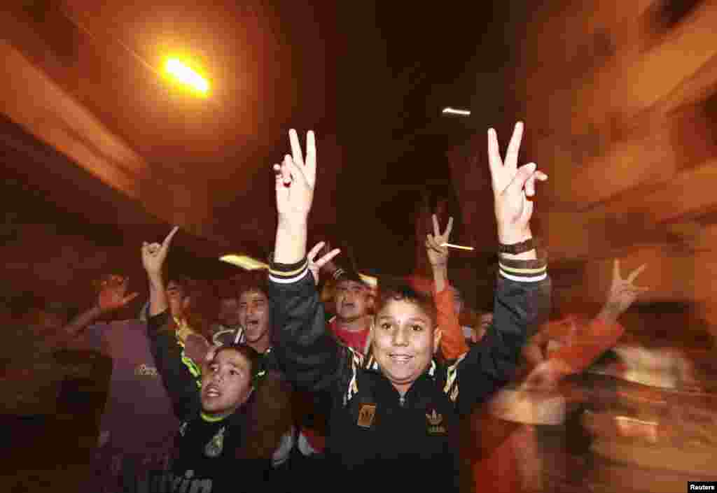 Palestinian boys celebrate what they say is a victory over Israel after an eight-day conflict in Gaza City November 21