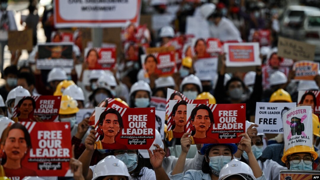 Para pengunjuk rasa mengangkat spanduk yang menuntut pembebasan pemimpin Myanmar yang ditahan Aung San Suu Kyi selama demonstrasi menentang kudeta militer 1 Februari di Yangon pada 10 Februari 2021. (Foto: AFP/Ye Aung Thu)